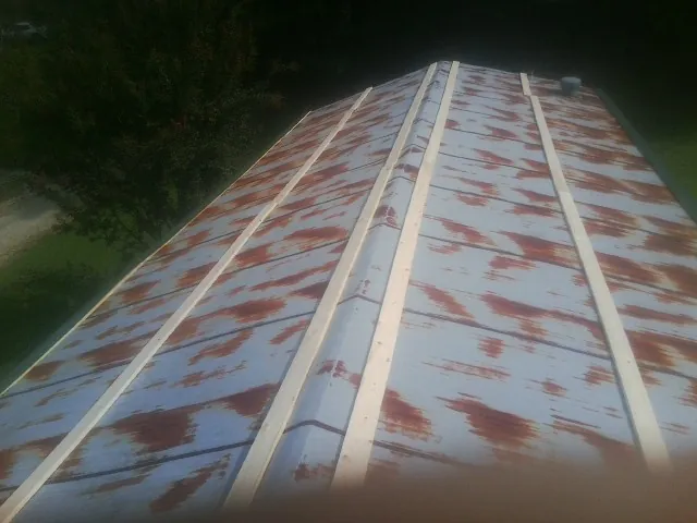 Rusted metal roof panels with new wood purlins before replacement — Storm Damage Roof Repair in Alton Bay by Roofing Brothers